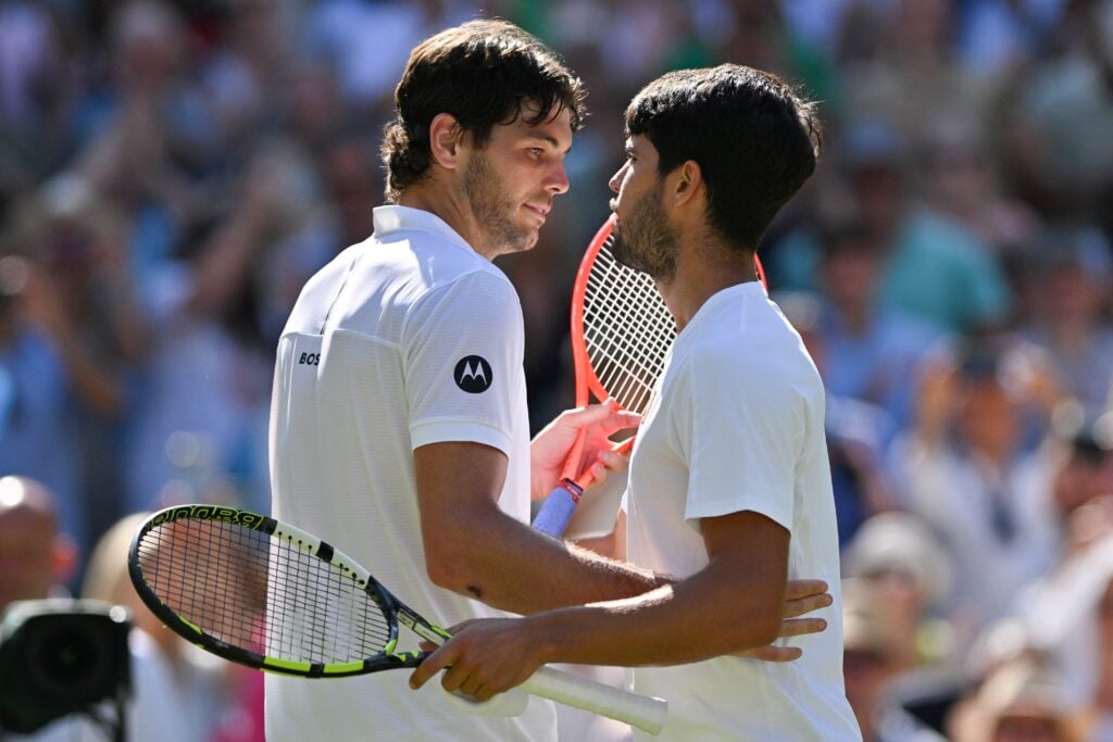 Carlos Alcaraz and Taylor Fritz embrace at the net after their 2025 Wimbledon semifinal