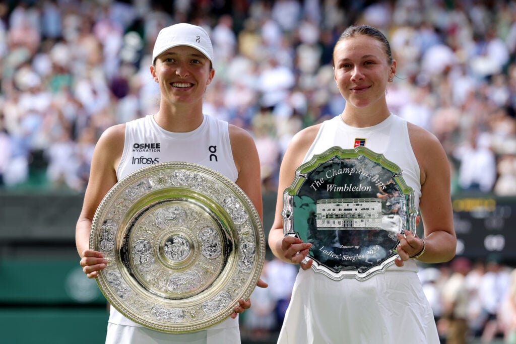 Iga Swiatek of Poland poses for a photo with the Ladies’ Singles Trophy alongside Amanda Anisimova of United States with the Ladies’ Singles Runner-Up Trophy, after the Ladies' Singles Final on day thirteen of The Championships Wimbledon 2025 at All England Lawn Tennis and Croquet Club.