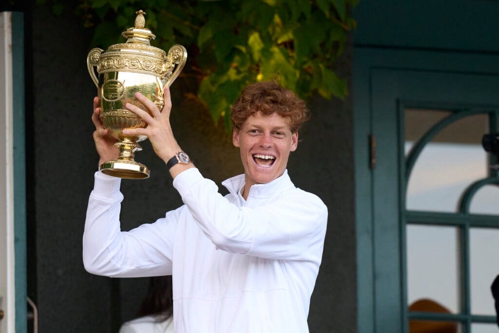 Jannik Sinner of Italy holds the Gentlemens' Singles Trophy, on the clubhouse balcony, after beating Carlos Alcaraz of Spain in the Gentlemens' singles final on Centre Court on day fourteen of The Championships Wimbledon 2025 at All England Lawn Tennis and Croquet Club.