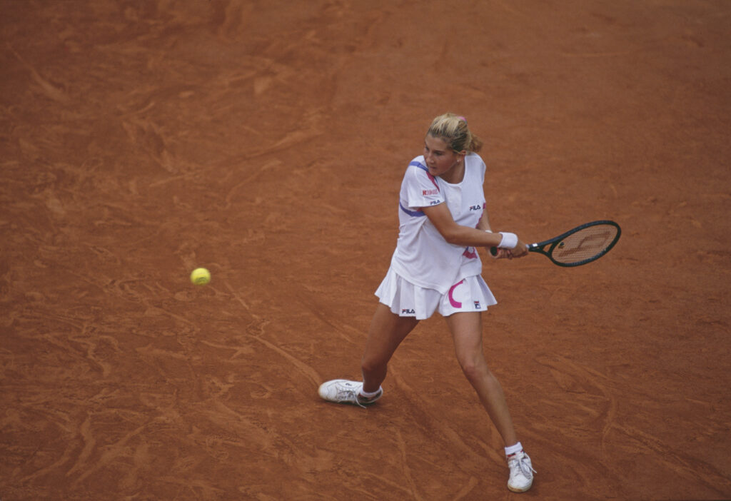 Monica Seles of Yugoslavia makes a double back hand return during the Women's Singles Final match against Steffi Graf at the French Open Tennis Championship on 9 June 1990 at the Stade Roland Garros in Paris, France.