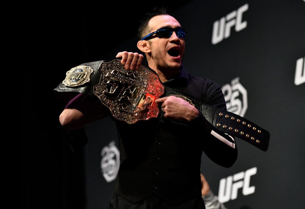 Tony Ferguson holds a UFC title during an appearance at a press conference