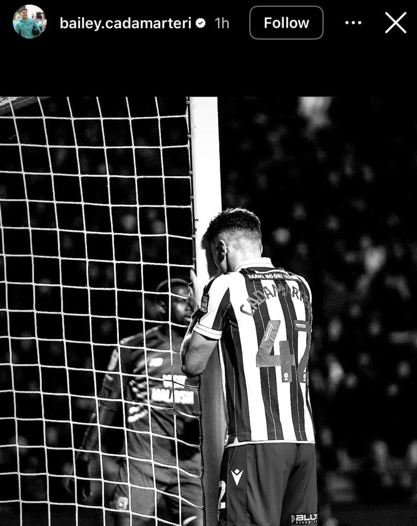 Bailey Cadamarteri hugging the post (in black and white)
