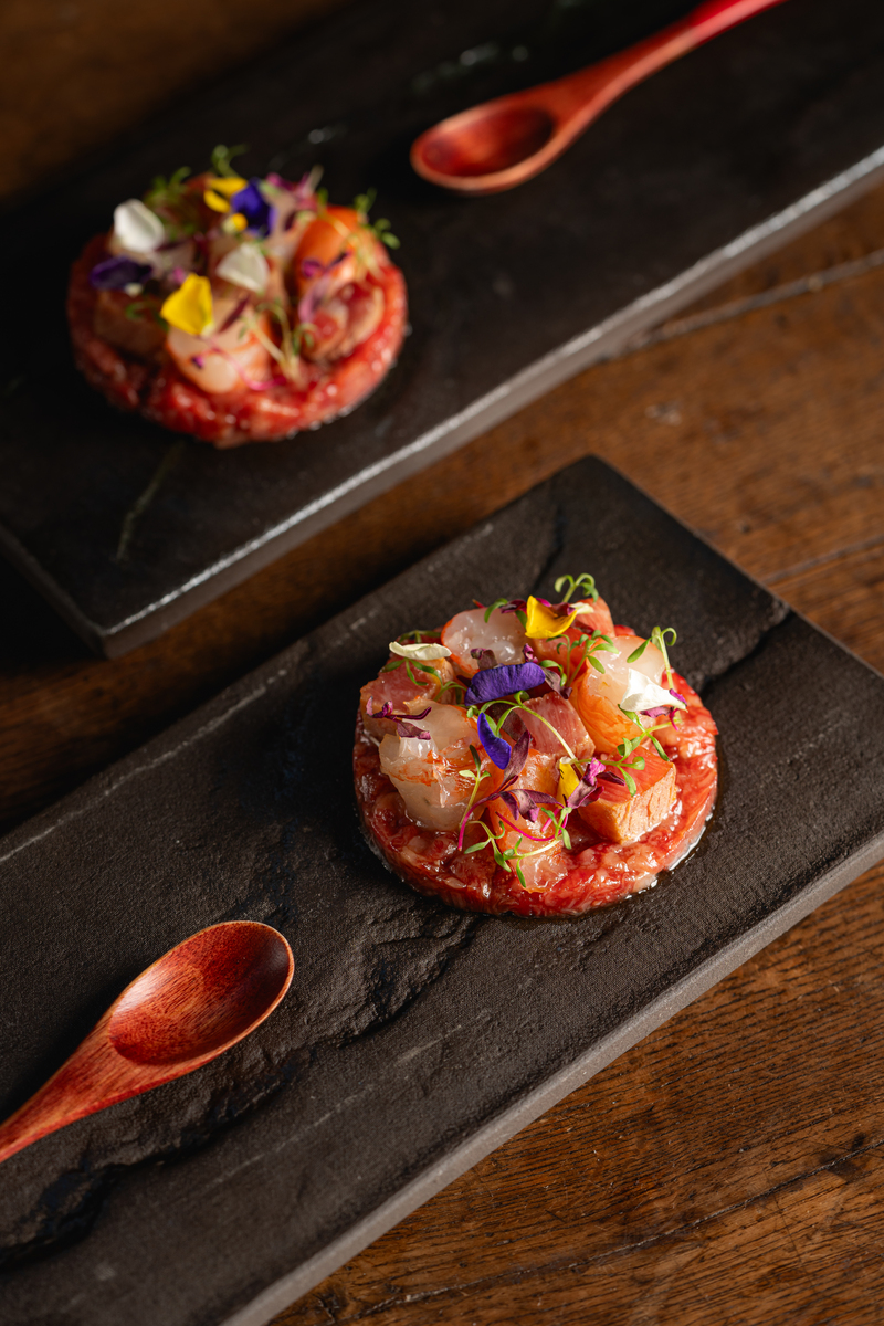 a raw wagyu dish topped with textural and herbal additions