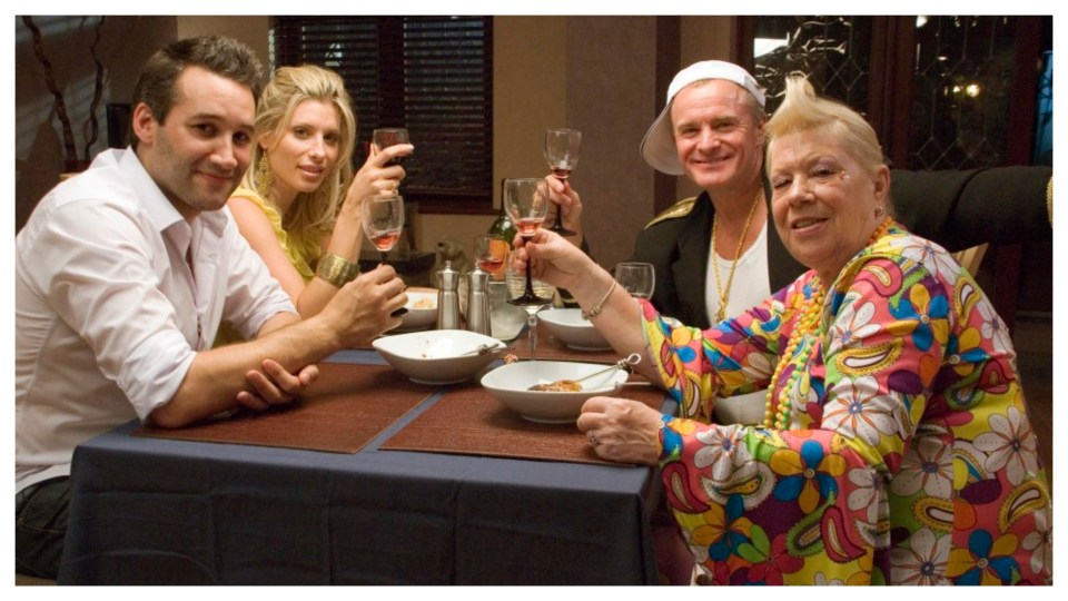 Four people toasting with wine at a dinner table.