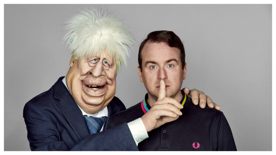 A man holds a Boris Johnson puppet, who is placing a finger to the man's mouth.