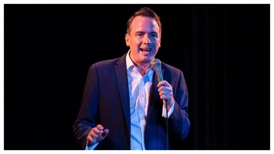 Man in suit speaking into microphone.