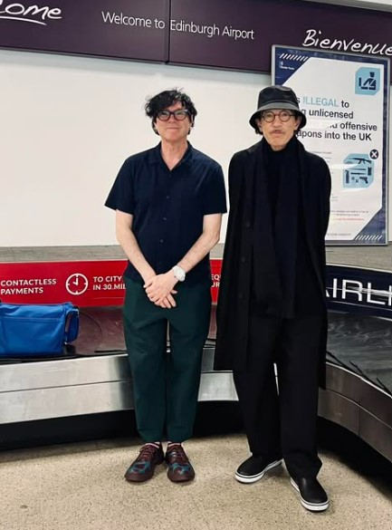 Two men at an airport baggage claim.