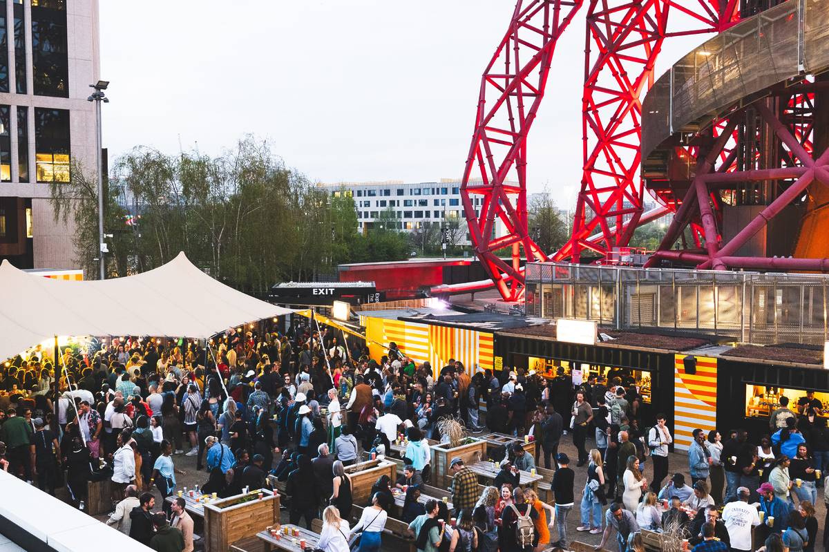 People gathered on Riverside East's roof terrae with a view of Stratford's giant slide in the background