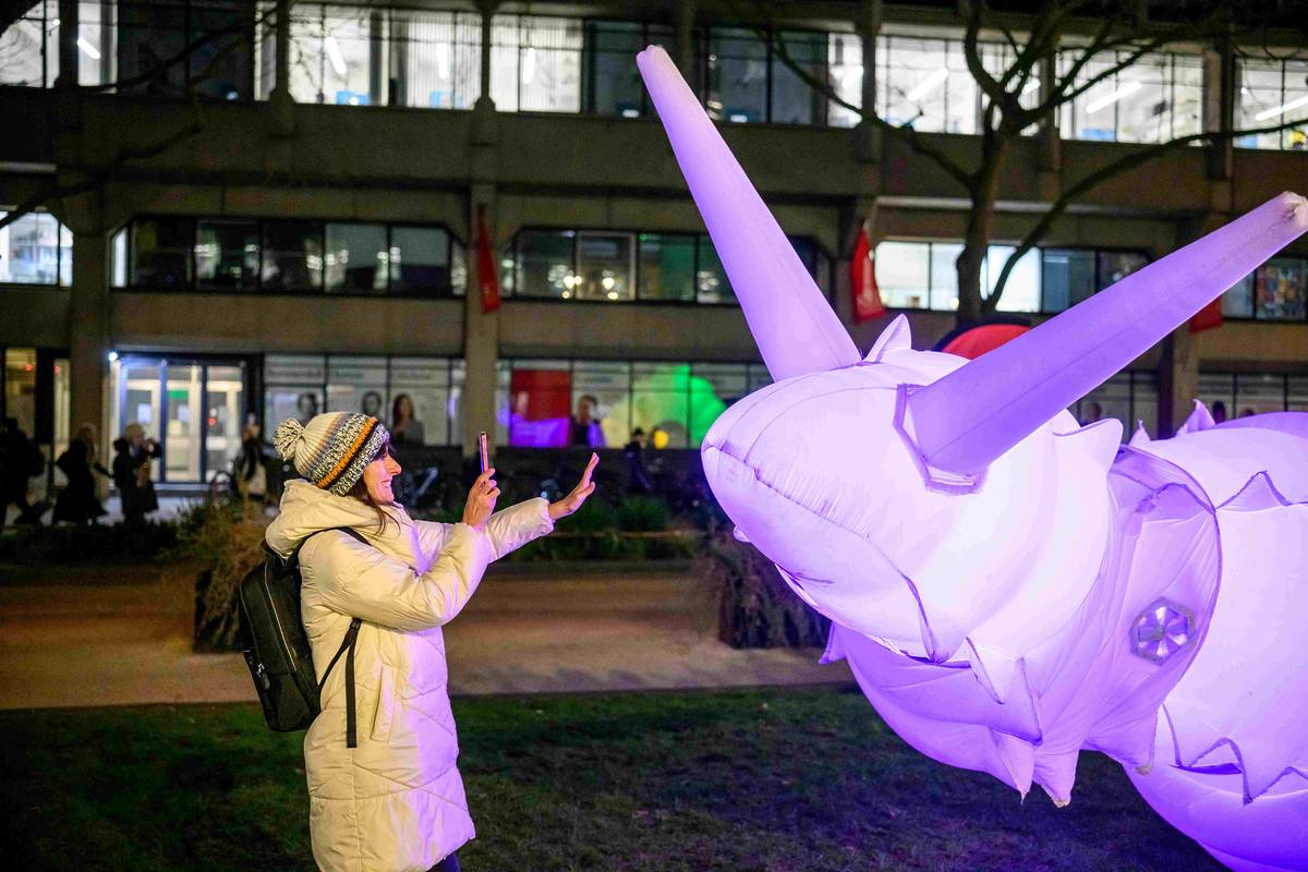 previous Air Giants inflatable work with woman taking photo on phone of it