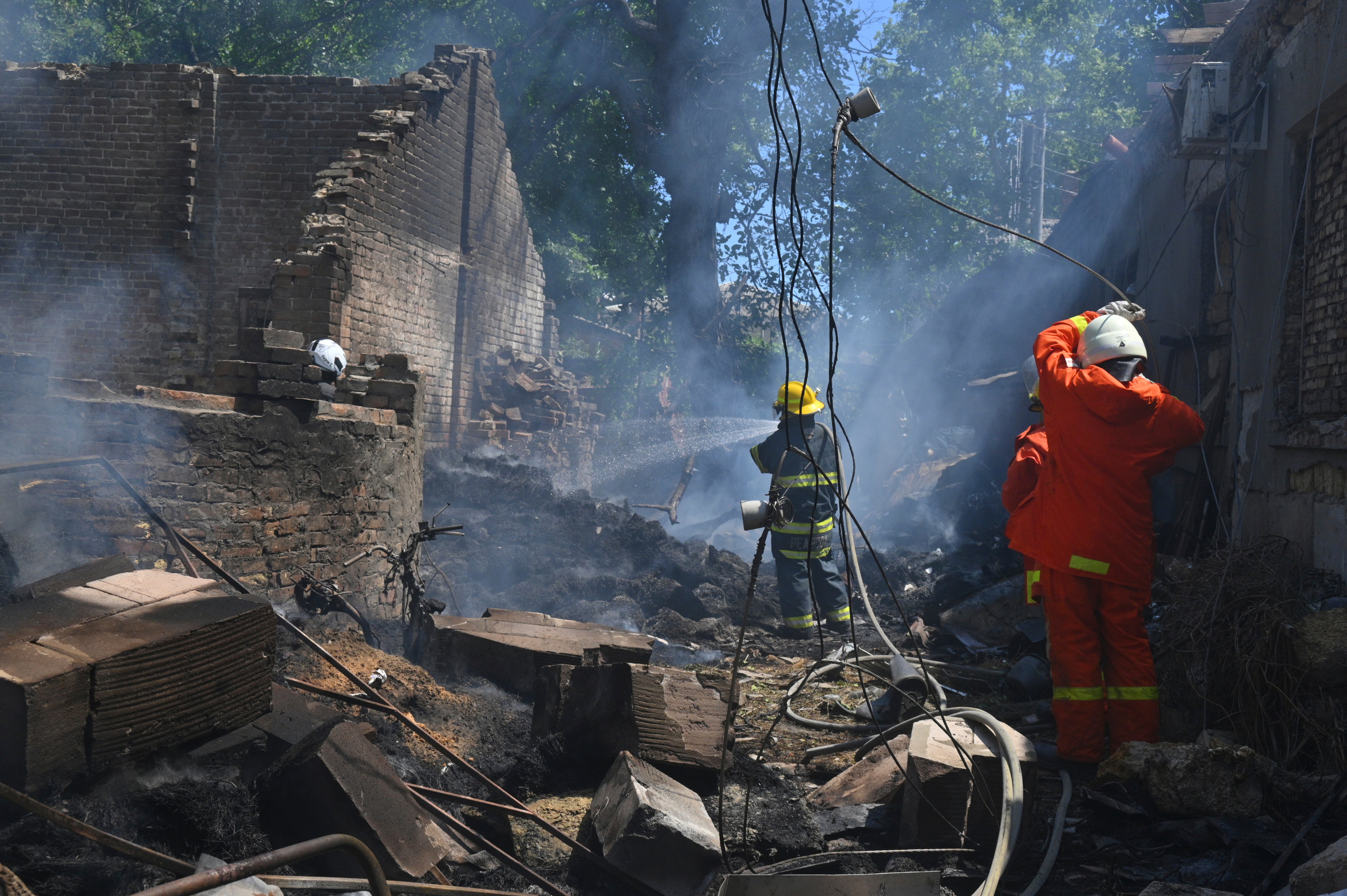 Emergency services personnel work to extinguish a fire following a Russian attack in Odesa, Ukraine, Friday, July 11, 2025.