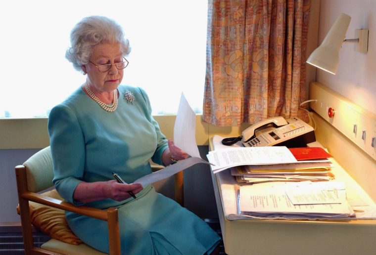 UNSPECIFIED LOCATION - MAY: Queen Elizabeth II works at her desk on the Royal Train in May of 2002.(Photo by Anwar Hussein/Getty Images)