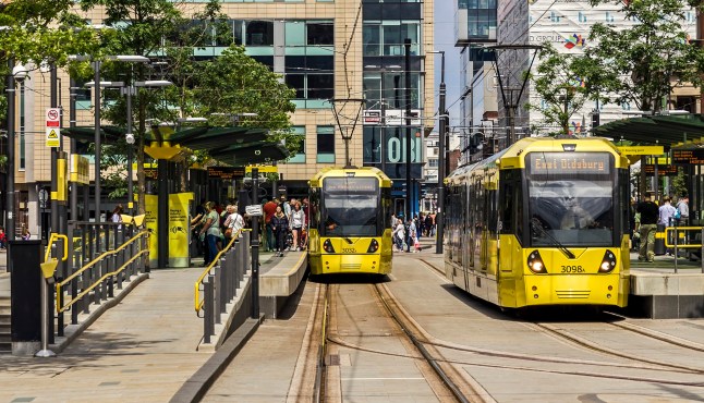 Manchester trams in the city centre at a stop.