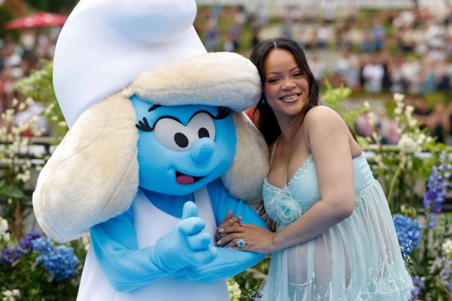 Rihanna poses with a person in a Smurfette costume for photographers upon arrival at the world premiere of the film 