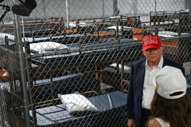 US President President Donald Trump speak with Secretary of Homeland Security Kristi Noem as they tour a migrant detention center, dubbed 