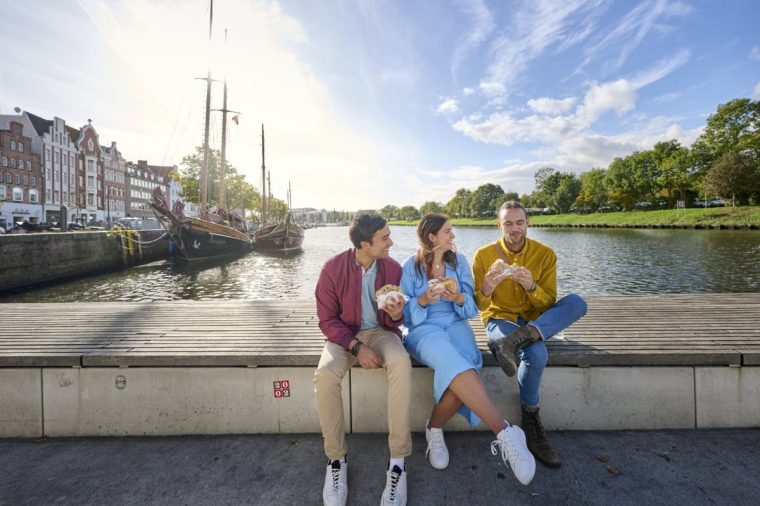 Friends eat fish sandwiches on the Trave L?beck Germany Credit: Jens Wegener/DZT Image via https://www.germany.travel/en/newsroom Freunde entdecken L??beck Altstadt