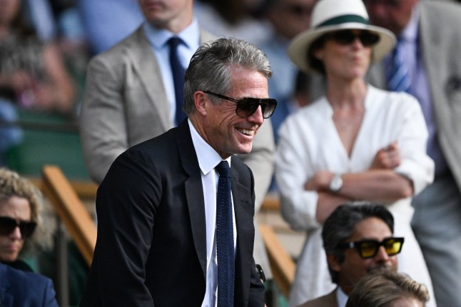 British actor Hugh Grant reacts in the royal box of Centre Court during the men's singles quarter-final tennis match between Serbia's Novak Djokovic and Italy's Flavio Cobolli on the tenth day of the 2025 Wimbledon Championships at The All England Lawn Tennis and Croquet Club in Wimbledon, southwest London, on July 9, 2025. (Photo by Kirill KUDRYAVTSEV / AFP) / RESTRICTED TO EDITORIAL USE (Photo by KIRILL KUDRYAVTSEV/AFP via Getty Images)