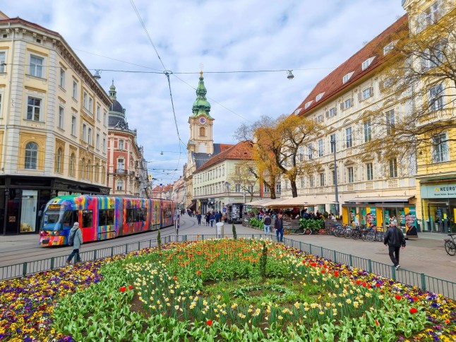 Graz, Austria - 26.03.2023: Colorful spring flowers in Jakominiplatz Square and Parish Church in the background, famous attraction in the city of Graz, Steiermark region, Austria. Selective focus; Shutterstock ID 2288927627; purchase_order: -; job: -; client: -; other: -