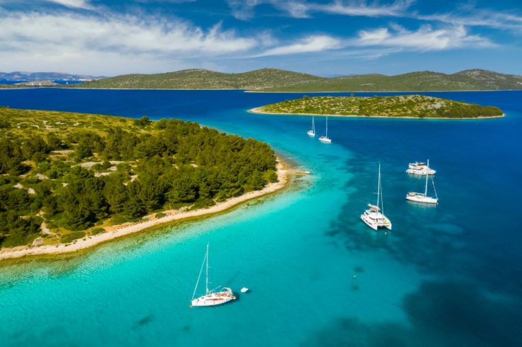 Yachts near the island in turquoise water