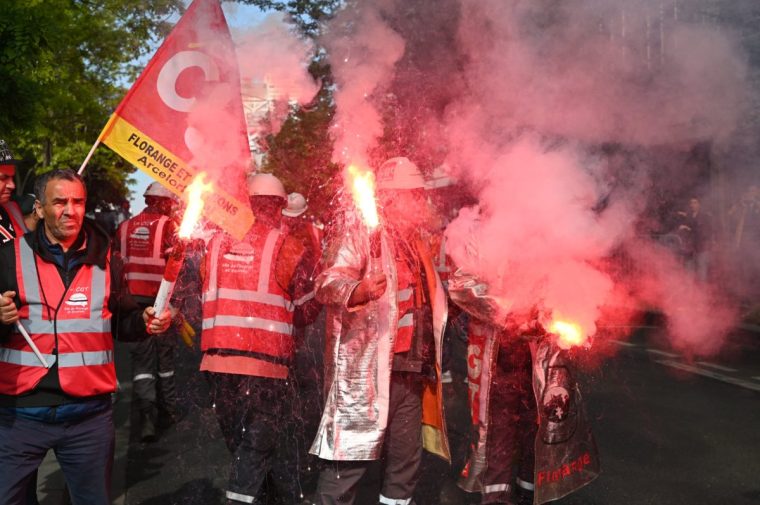 Employees take part in a rally held outside ArcelorMittal headquarters to put pressure on the French management of the steelmaker, which is planning to cut more than 600 jobs in Saint-Denis near Paris, on May 13, 2025. (Photo by LEO VIGNAL / AFP) (Photo by LEO VIGNAL/AFP via Getty Images)