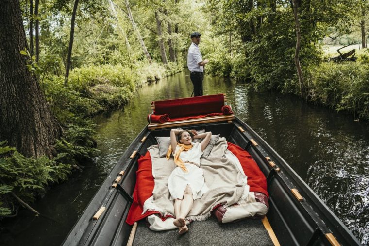 Woman spending vacation lying on boat in canal