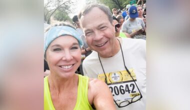 Woman and man in a crowd take selfie of themselves smiling