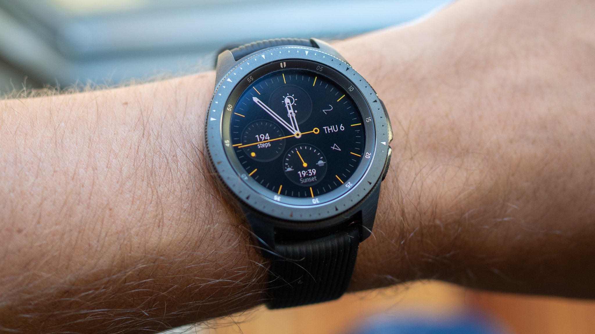 The Samsung Galaxy Watch 3 worn on someone's left wrist, showing an analogue watch face and steel rotating bezel.