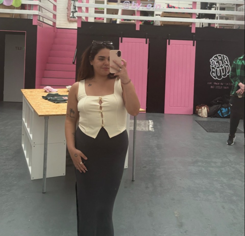 Woman taking a selfie in a clothing store.