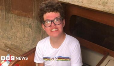 Family photo of Fraser. He is wearing a white T-shirt and glasses