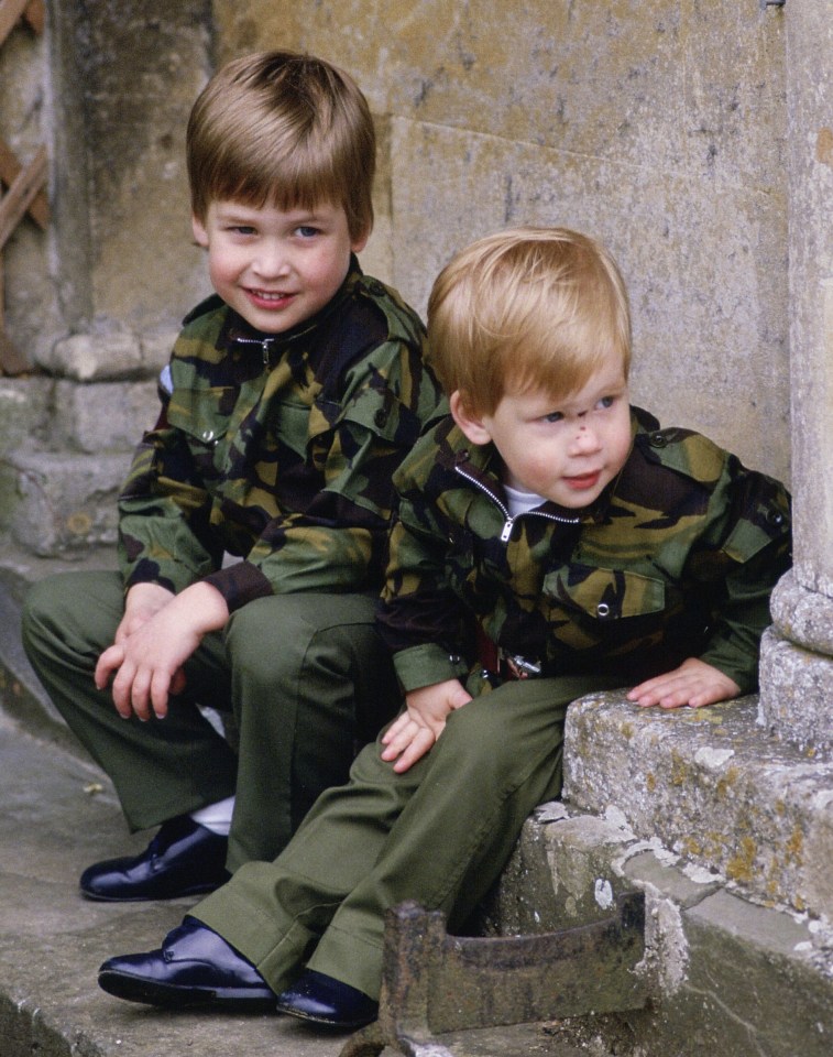 two young boys wearing camouflage jackets sit on steps