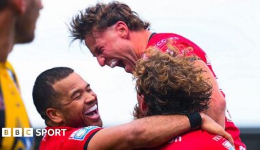 Salford Red Devils player Joe Mellor shouts in celebration and is embraced by teammates after scoring a try against Castleford Tigers.