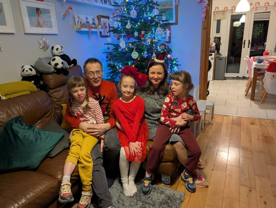 Family portrait in front of a Christmas tree.