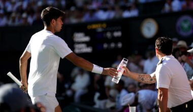 Carlos Alcaraz passes water for a fan amid record-breaking heat at Wimbledon on Monday.