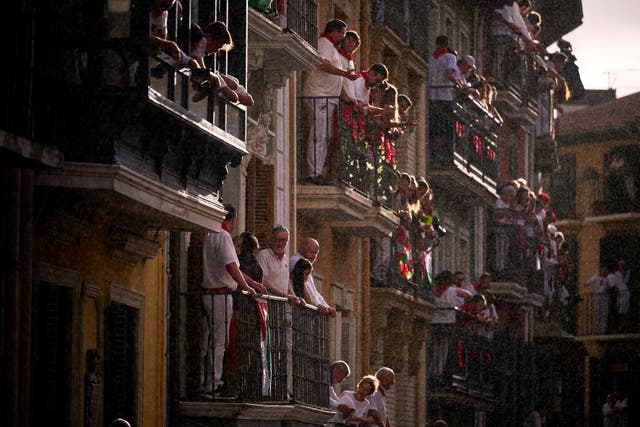 People hang over balconies waving flags