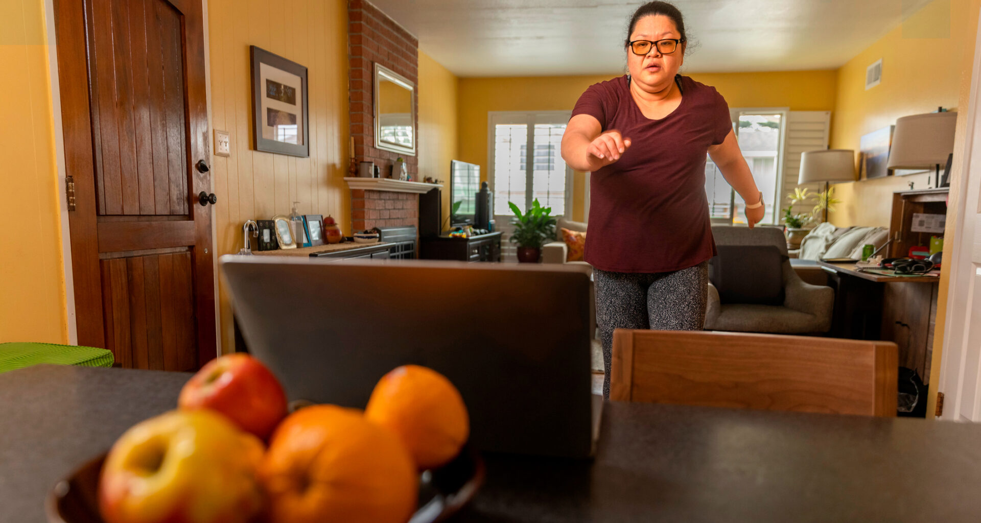 Woman exercising in front of a laptop at home
