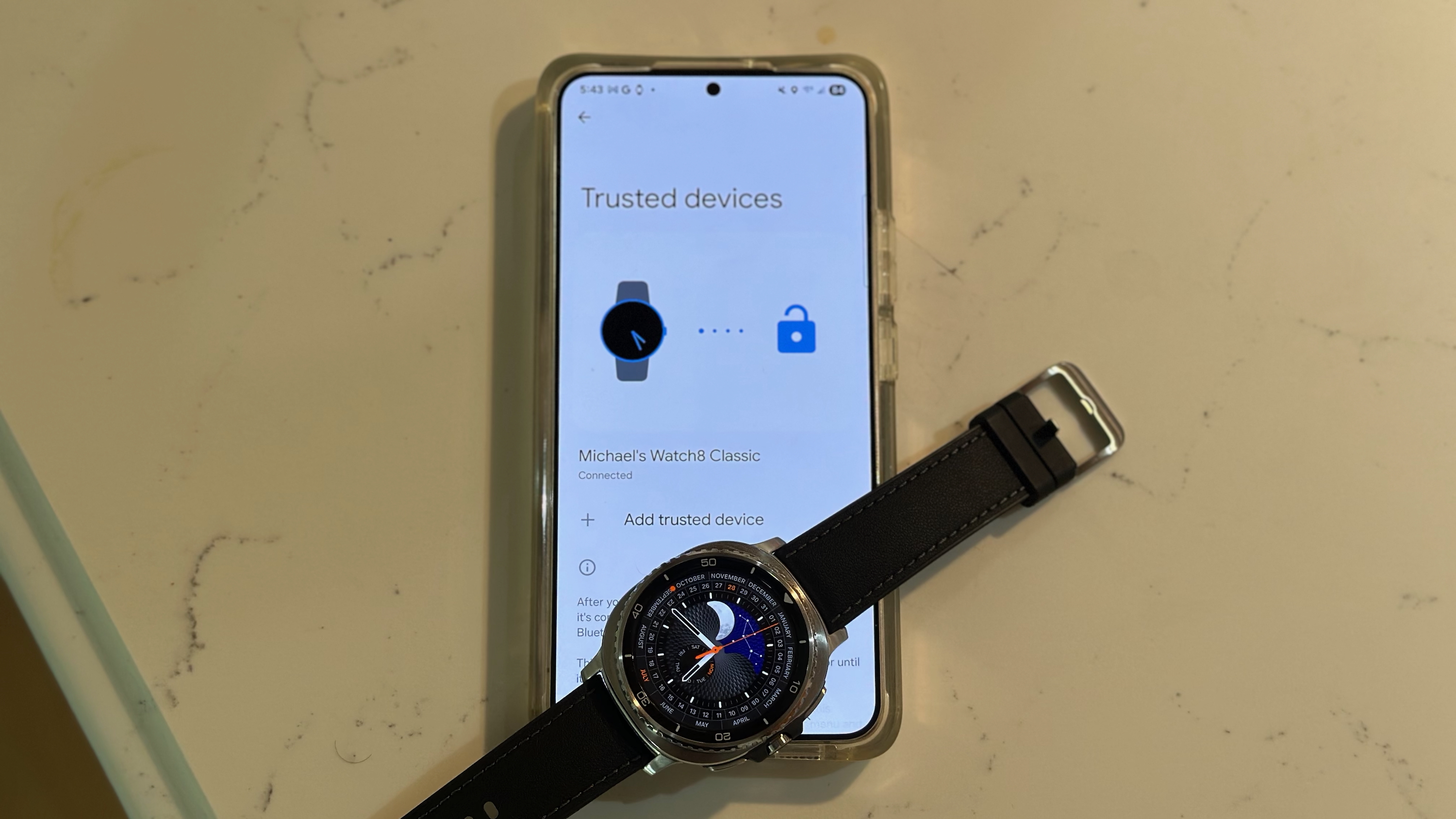 The Samsung Galaxy Watch 8 Classic sitting on a Galaxy phone showing the 