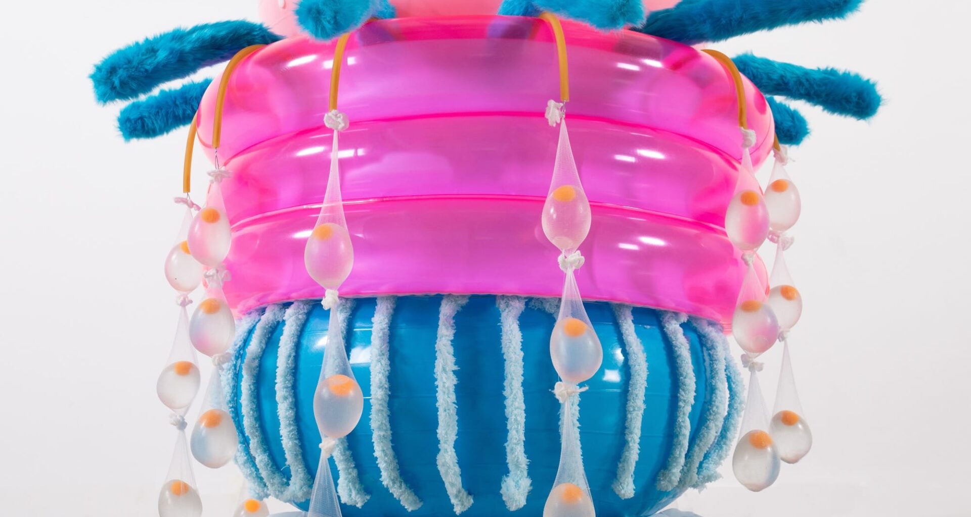 an abstract inflatable artwork that resembles a pink and blue, alien-like creature