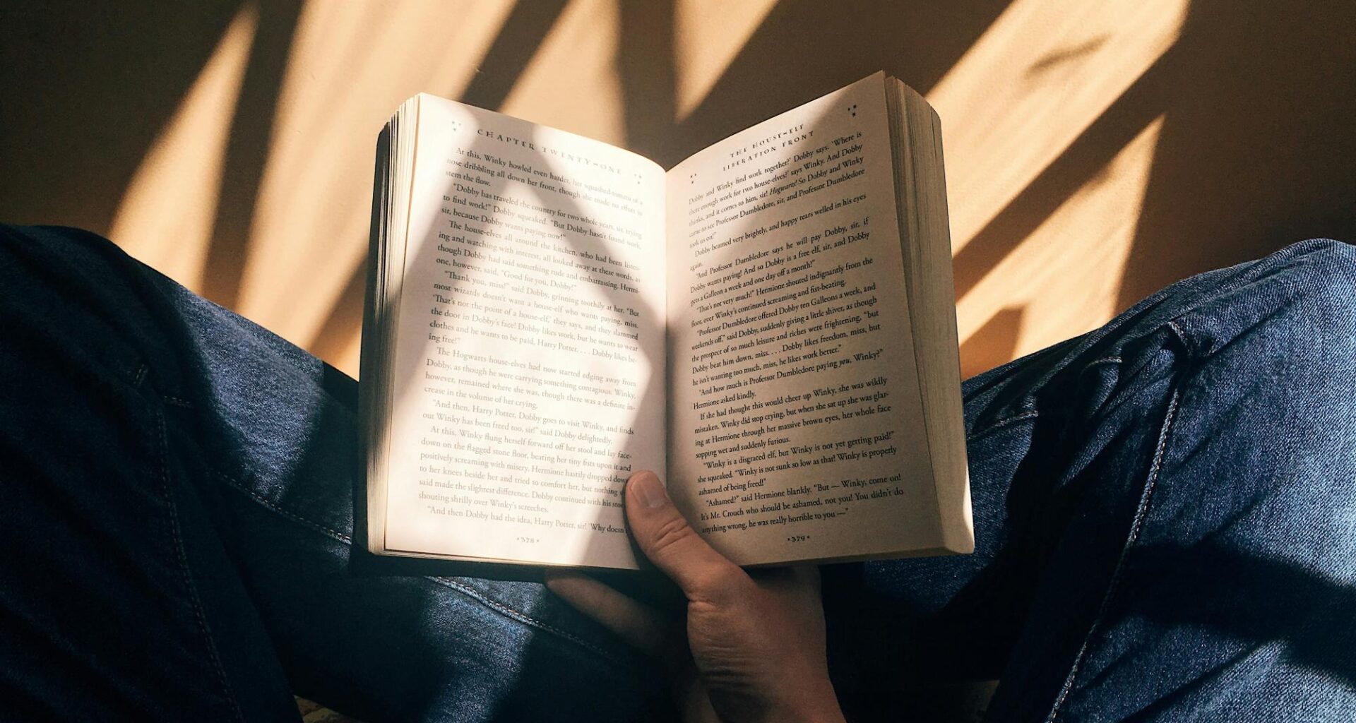 A person sitting cross-legged holding a book open. Publishing after book rejection