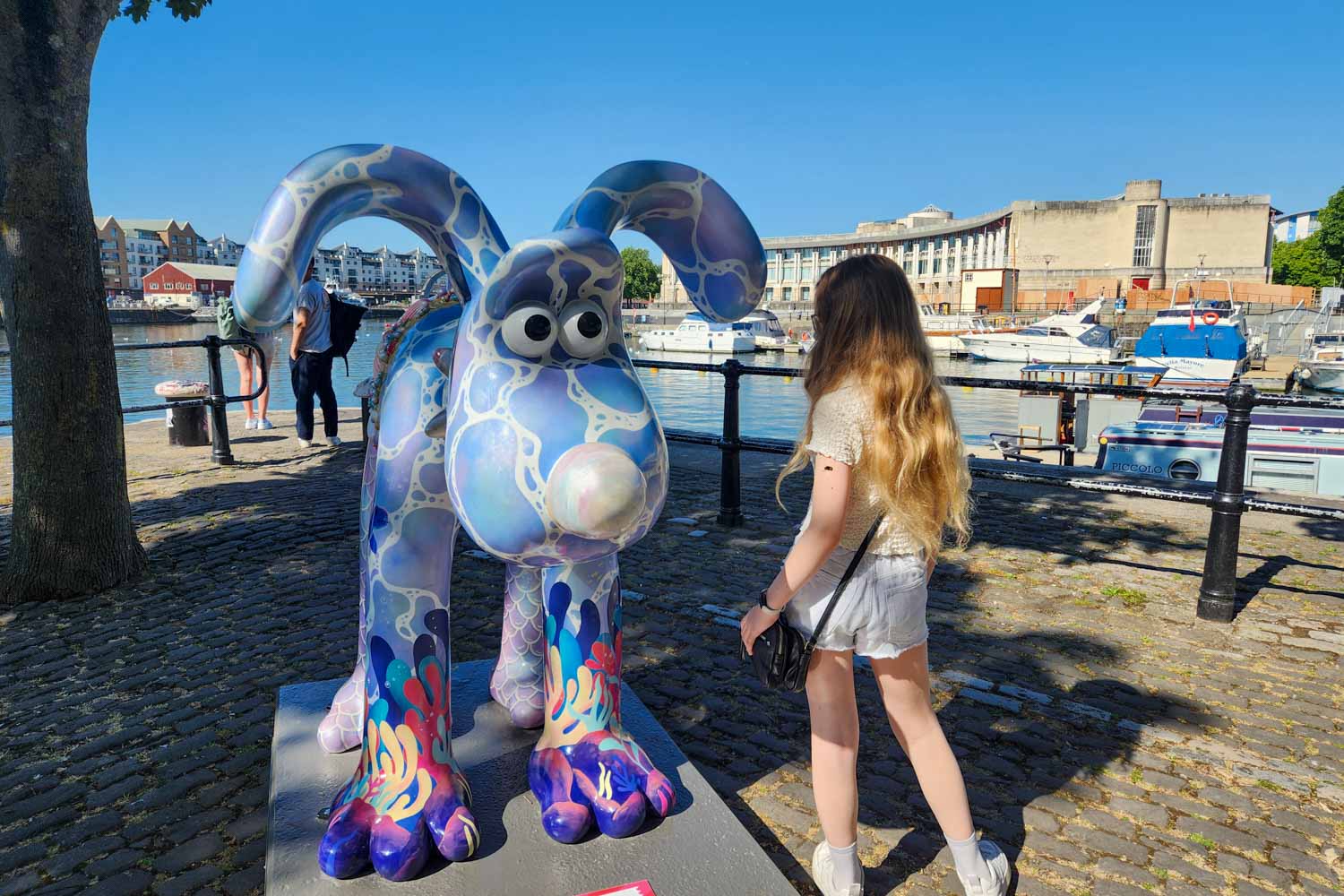My daughter looks at a sea-themed statue of Gromit by the Harbourfront in Bristol - my Gromit Unleashed 3 review of a visit to Bristol with kids