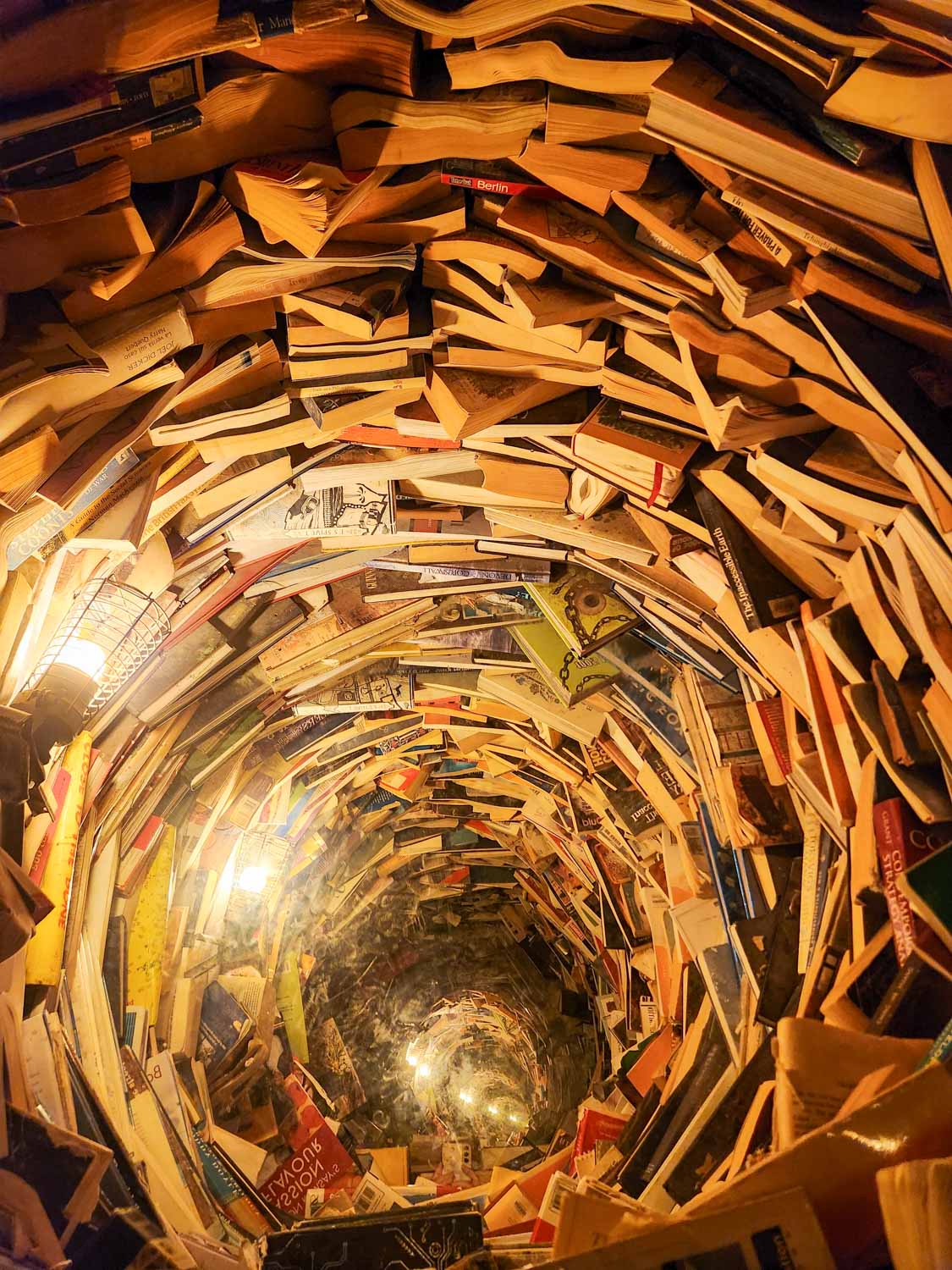 Optical illusion of a well made of books at Wake The Tiger - one of the most unusual things to do in Bristol with kids
