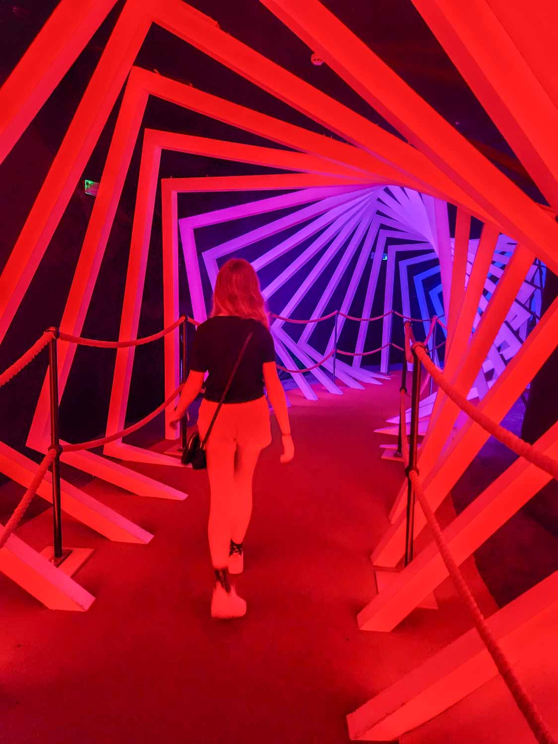 My daughter walks through a tunnel created using light and shapes to trick the eyes - one of the most unusual things to do in Bristol with kids