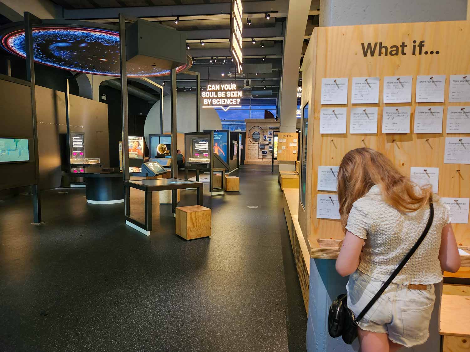 My daughter writes on a card to add to one of the displays at We The Curious science centre during a short break in Bristol with kids