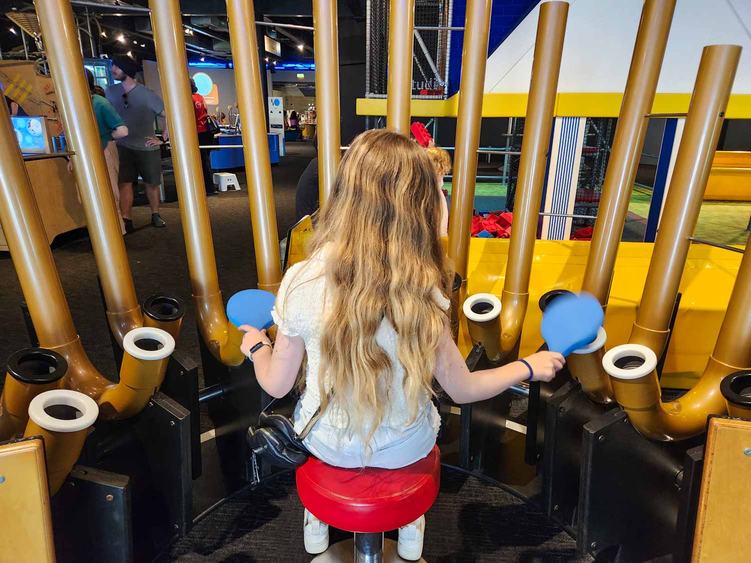 My daughter experiments with sound at We The Curious interactive science centre during a short break in Bristol with kids