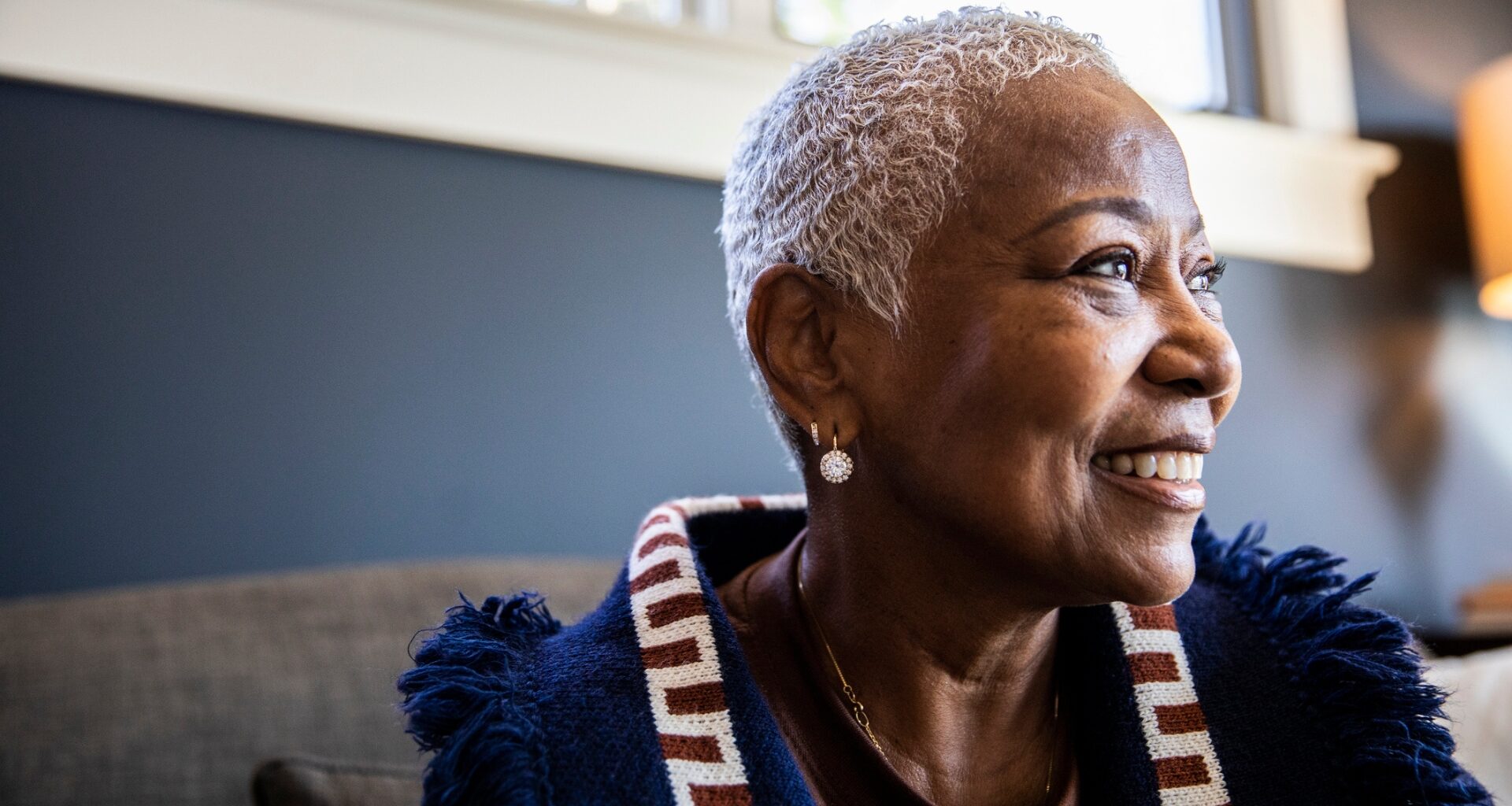 older woman looking sideways to the camera with a smiling happy face.