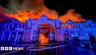 The facade of Odesa's market at nighttime, with a fire raging behind it