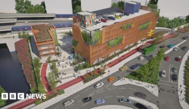 An artist's impression of plans for a new transport hub at Bristol Temple Meads Station. It is a large brown building with a colourful mural on one part of it. People can be seen walking in front of it.