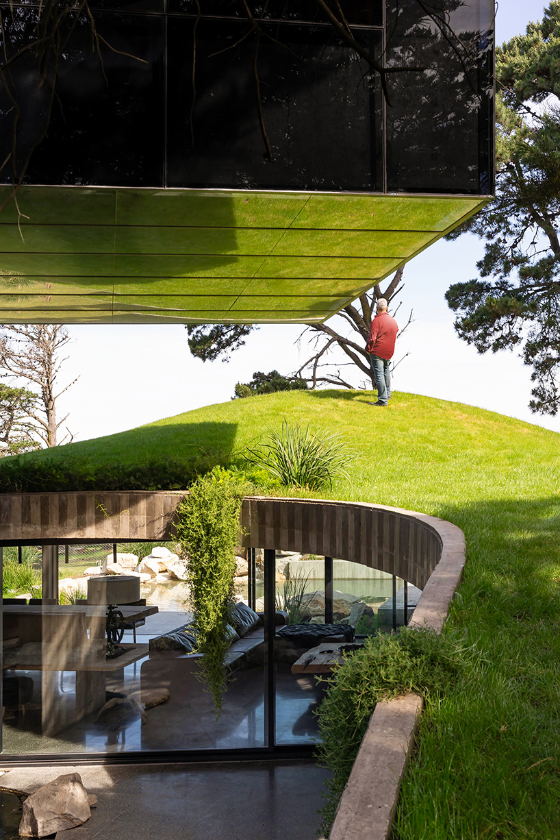 casa moro's green concrete mantle follows natural slope of forested terrain in buenos aires