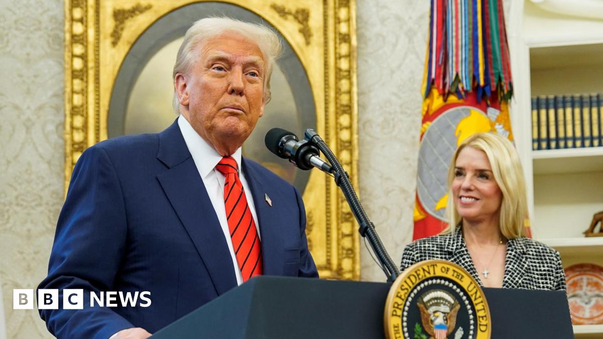 Donald Trump wears a blue suit, red tie with Pam Bondi standing next to him