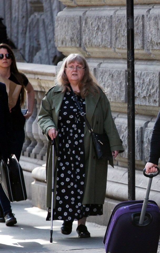 Woman with cane walking outside Central London County Court.