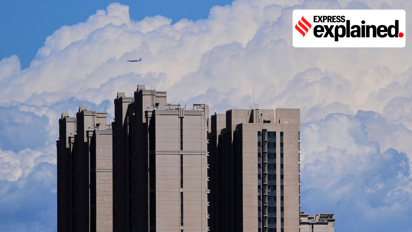 A passenger airliner flies past the clouds near a residential building in Beijing, China, on July 13, 2025.