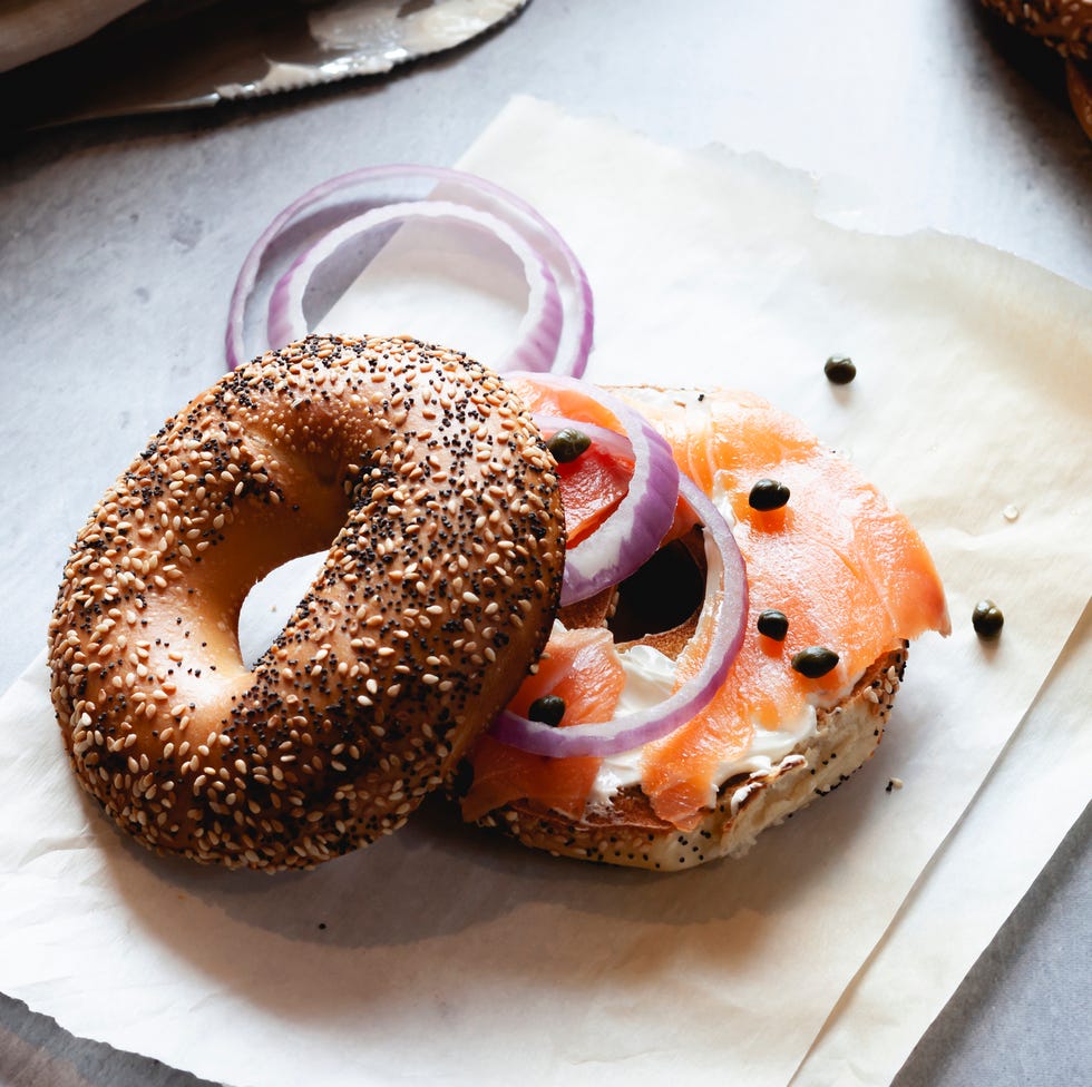 closeup of lox bagel with onions on paper sheet